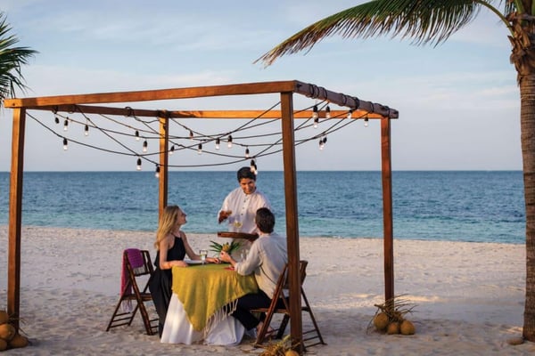 A couple enjoying private beachfront dinning